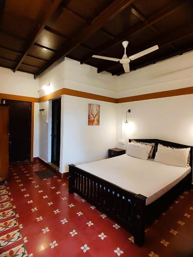 a bedroom with a large bed in a room at Bunk Club Hostel in Vandiperiyār
