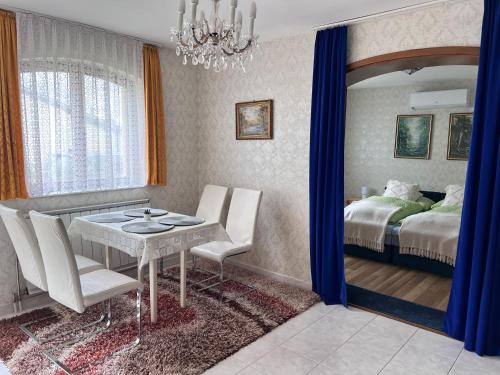 a dining room with a table and a bedroom at Horváth apartaman in Hévíz