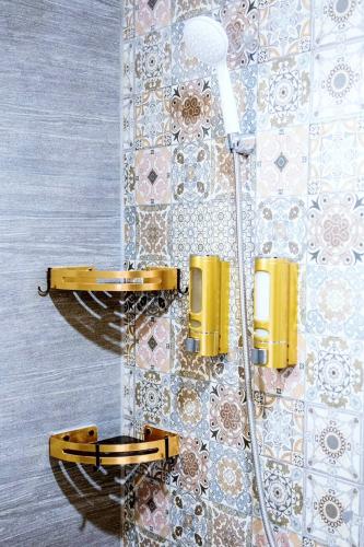 a shower in a bathroom with a wall at Secluded Apartment with Full Kitchen & Balcony Garden View in Liloan
