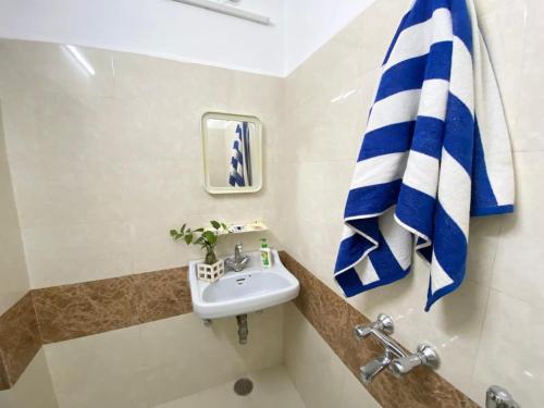 a bathroom with a sink and a blue and white towel at Garden View Residency, Deluxe Queen Room 1 in Lucknow