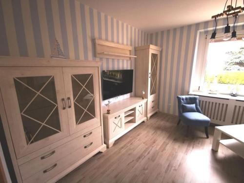 a living room with a tv and a cabinet at Holiday apartment Gitti Ueckermünde in Ueckermünde