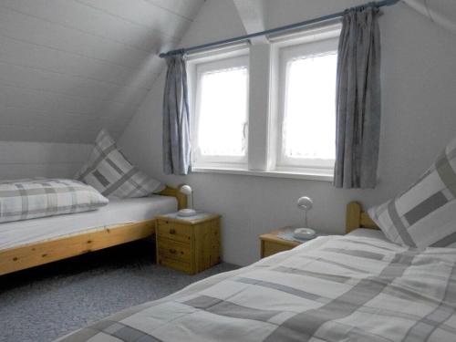 a bedroom with two beds and two windows at Jacobi Comfortable holiday residence in Bad Harzburg