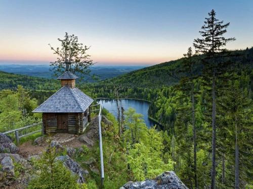 a small cabin on the side of a mountain with a lake at in the country house at the national park in Lindberg
