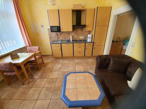 ein Wohnzimmer mit Couch und Tisch und eine Küche in der Unterkunft House Neeltje, Apartment 1 in Borkum