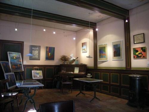a room with a table and paintings on the wall at "Ancien Cafe" with roof terrace and balcony in Camplong-dʼAude