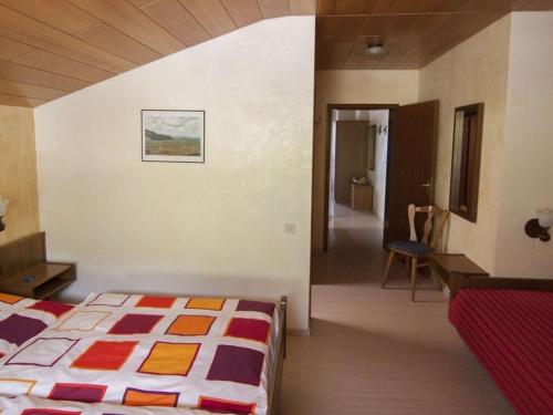 a bedroom with a bed and a hallway with a chair at Haus Fernblick Apartment 1 in Bad König