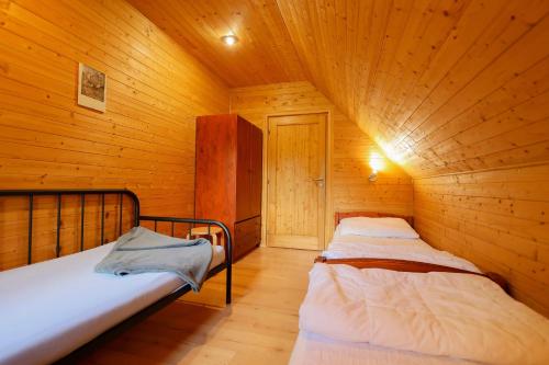 a bedroom with two beds in a wooden cabin at Chalupa s privátní saunou in Dolní Morava