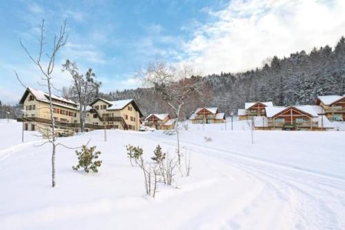a snow covered field with houses and trees at Appart cosy avec vue sur Lac in Lugrin