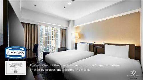 a hotel room with two beds and a window at Daiwa Roynet Hotel Nishi-Shinjuku PREMIER in Tokyo