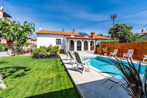 a backyard with a swimming pool and a house at House with private pool 150 m from sea! in Fažana