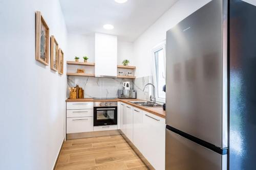 a kitchen with white cabinets and a stainless steel refrigerator at House with private pool 150 m from sea! in Fažana