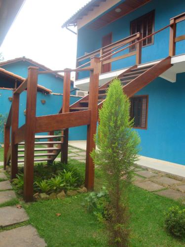 a blue house with a tree in front of it at Pousada Bugio in Abraão