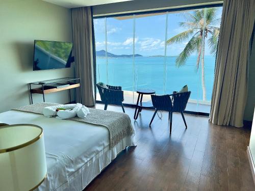 a hotel room with a bed and a view of the ocean at 苏梅岛观景台海景別墅Golden Coconut Villa 5 超级海景 私密泳池 接送服务 in Koh Samui 