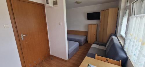 een kleine kamer met een bed en een deur bij Ośrodek Wypoczynkowy Ostoja in Dźwirzyno