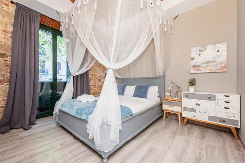 ein Schlafzimmer mit einem Himmelbett und einer Kommode in der Unterkunft Midtown Luxury Apartments by Sweett in Barcelona