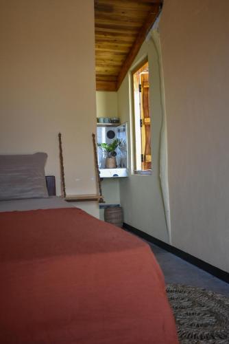 a bedroom with a bed and a window at Salty Alchemy in Arugam Bay