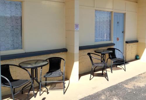 un par de sillas y mesas en un patio en Warren Motor Inn en Warren