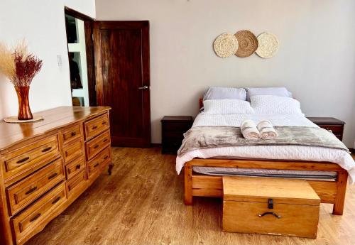 a bedroom with a bed and a dresser with two hats at Martita's Home in Loja