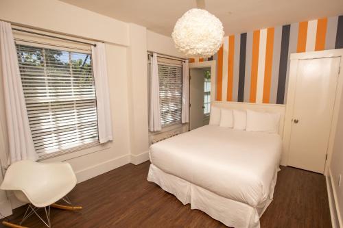 1 dormitorio con 1 cama blanca y 1 silla blanca en Edwardian Hotel, en San Francisco