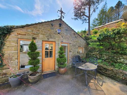 a small brick building with a table and a table sidx sidx sidx at Rural Peak District retreat in Little Hayfield One bedroom self contained property Dogs welcome in Highpeak Junction