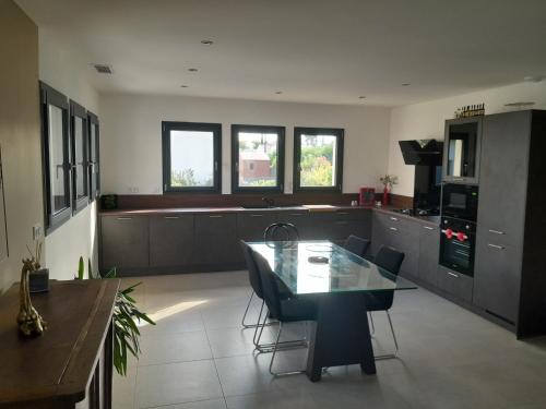 une grande cuisine avec une table et des chaises. dans l'établissement Paisible villa plain pied 110m2, à Saint-Nazaire