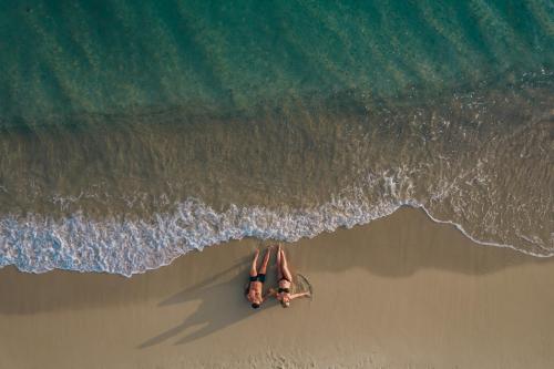 twee mensen op een surfplank op het strand bij Aegean Palace in Plaka