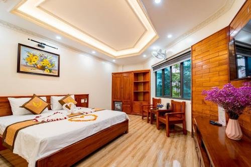 a bedroom with a bed and a table in a room at Quỳnh Anh Luxury Hotel Sầm Sơn in Sầm Sơn
