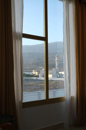 a window with a view of a city at Al Rawnaq Studio in Al Ḩamrāʼ