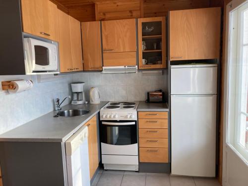 eine Küche mit einem weißen Herd und einem Kühlschrank in der Unterkunft Koli Country Club in Kolinkylä