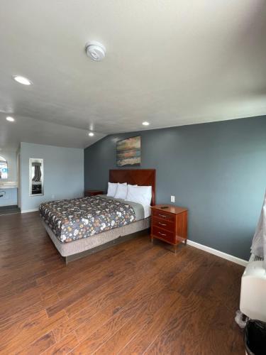 a bedroom with a bed and a wooden floor at Sunny Sands Inn in Costa Mesa
