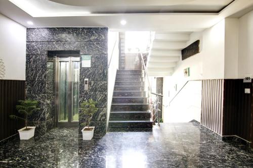 a staircase in a building with potted plants at Hotel Grand Manor in Gurgaon