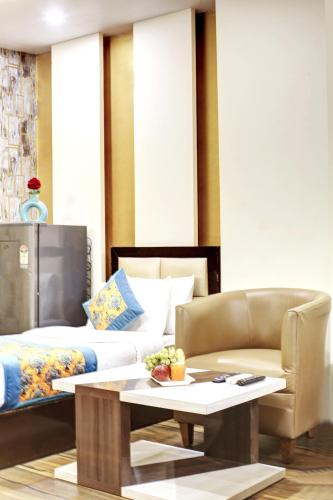a living room with a bed and a coffee table at Hotel Grand Manor in Gurgaon
