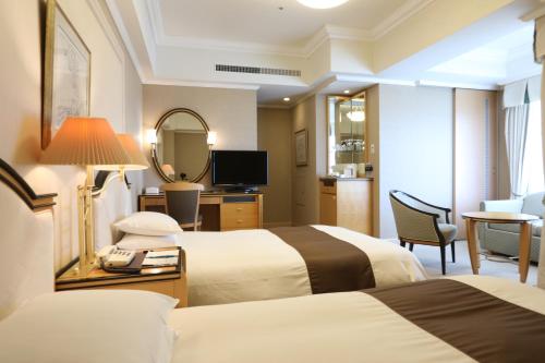 a hotel room with two beds and a mirror at Imabari Kokusai Hotel in Imabari