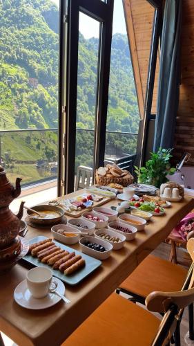 ein Tisch mit Tellern voller Essen darauf in der Unterkunft Valent Suit Bungalov in Ardeşen