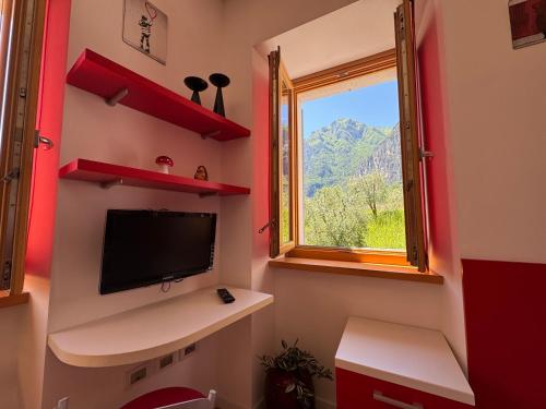 a small room with a tv and a window at Das Rote Haus in Riva del Garda