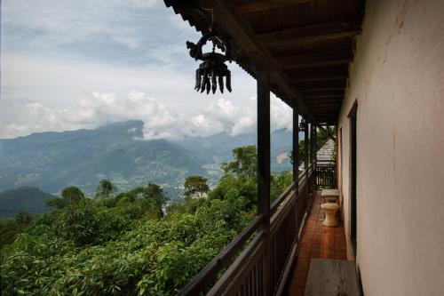 a balcony of a house with a view of the mountains at The Famous Farm in Nawākot