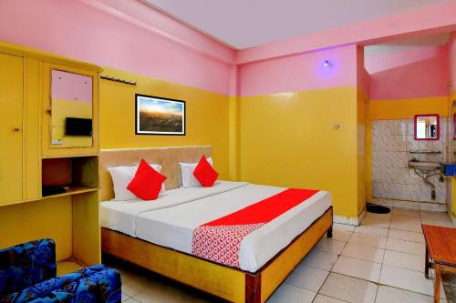 een slaapkamer met een bed met rode kussens bij OYO Hotel Bhaba Lakshmi in Bhubaneshwar