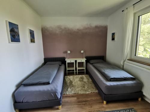a room with two beds and a table and a window at Silent Hill House in Bleckede