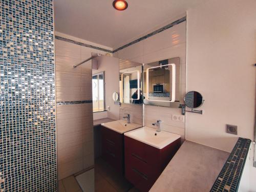 une salle de bain avec deux lavabos et un miroir dans l'établissement Studio 404 Héliopolis naturiste, au Cap d'Agde