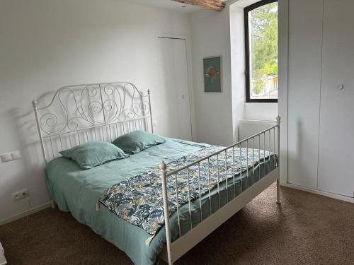 - une chambre avec un lit doté d'une tête de lit en métal dans l'établissement Le Mas de L'Olivier, à Saint-Maurice-sur-Eygues