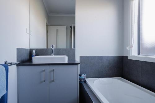 a bathroom with a bath tub and a sink at Home away from home in Wyndham Vale