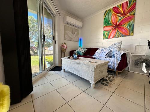 ein Wohnzimmer mit einem Sofa und einem Tisch in der Unterkunft Holiday at Henry St West End, Townsville QLD 3 night min in North Ward