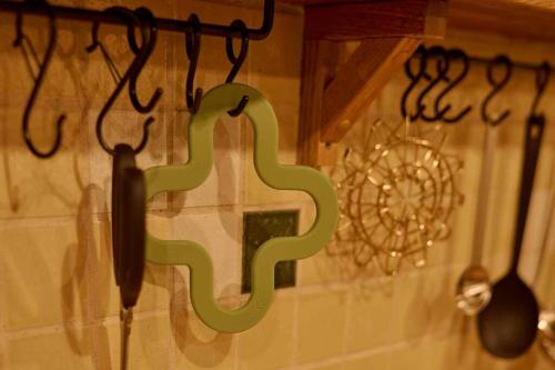 a green sign is hanging on a wall with utensils at Miki in Osaka