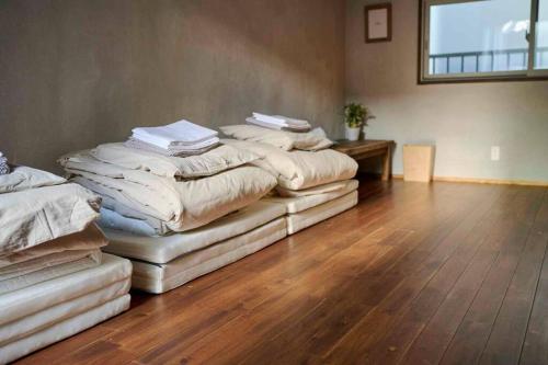 four stacks of blankets sitting on top of a wooden floor at Miki in Osaka