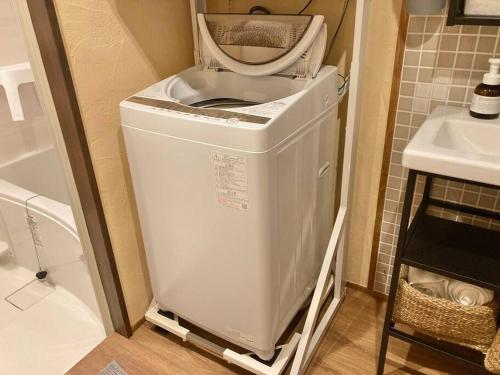 a washing machine in a bathroom next to a sink at Miki in Osaka