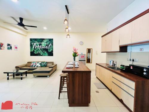 a kitchen and living room with a couch and a table at Maison life 小居屋 The Loft Imago in Kota Kinabalu