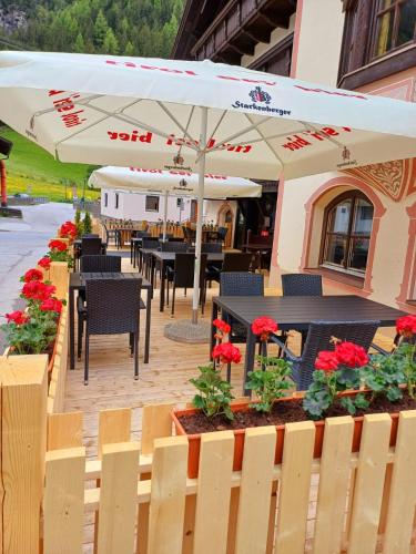 a restaurant with tables and chairs and umbrellas at Hotel Restaurant Liesele Sonne in Sankt Leonhard im Pitztal