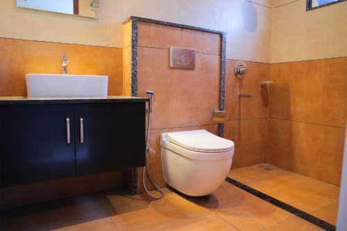 a bathroom with a toilet and a sink and a shower at Spring Valley Resort in Thekkady