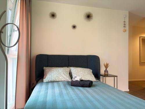 una camera da letto con un letto blu con due punte sul muro di Hill Namai a Palanga