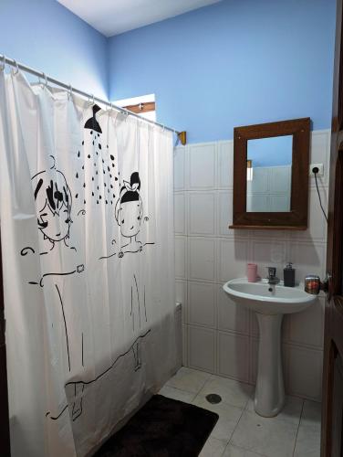 a bathroom with a shower curtain and a sink at Apartment Funana Tarrafal in Tarrafal